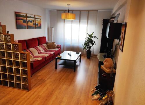 - un salon avec un canapé rouge et une table dans l'établissement Acogedor Rincón Charro 75m2 Junto al Corte Ingles y Zona de Tapas de Van Dyck, à Salamanque