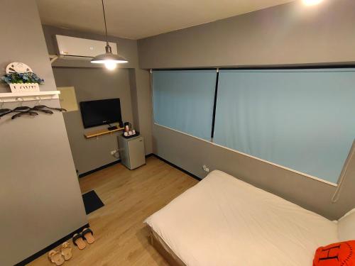 a small room with a bed and a sliding glass door at 駐典Txg in Taichung