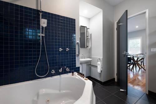 a bathroom with a bath tub and a sink at Lake Orchard Villas in Daylesford