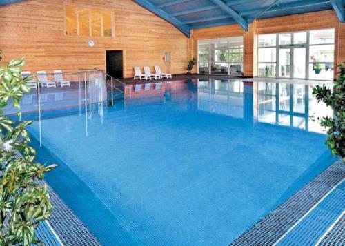 a large swimming pool with blue water in a building at Chy Lowen - Atlantic Reach in Newquay