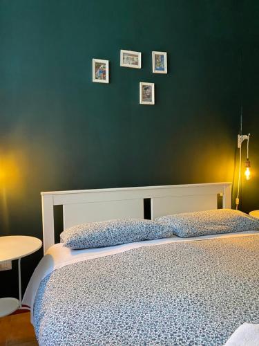 ナポリにあるB&B La Terrazza Napoliの緑の壁、ベッド付きのベッドルーム1室