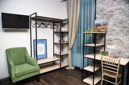 a living room with a green chair and shelves at REDROOF country house hotel in Goris