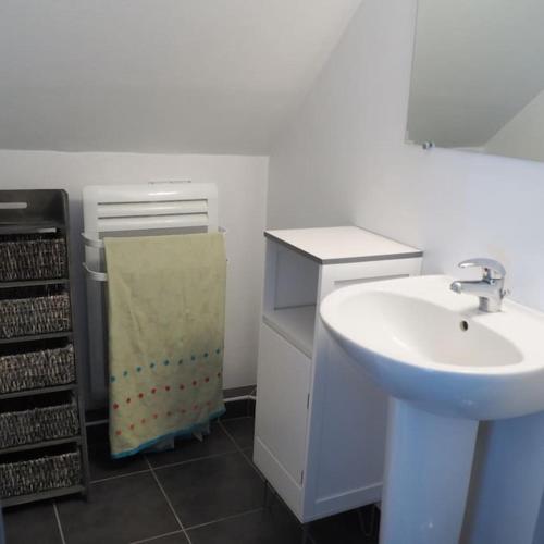 La salle de bains blanche est pourvue d'un lavabo. dans l'établissement Appartement duplex et terrasse à St Servan-St Malo, à Saint-Malo