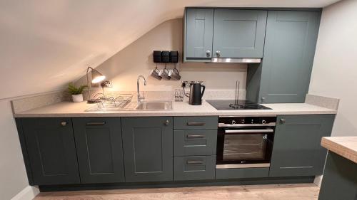 a kitchen with gray cabinets and a sink at CHAMBERS RISE - City Centre Stays in Derry Londonderry