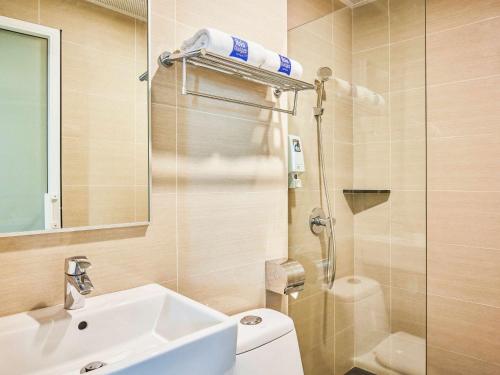 uma casa de banho com um lavatório, um WC e um chuveiro em ibis budget Singapore Emerald em Singapura