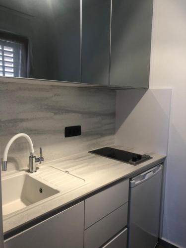 a kitchen with a sink and a counter top at Apartments & Rooms Bianca in Mali Lošinj