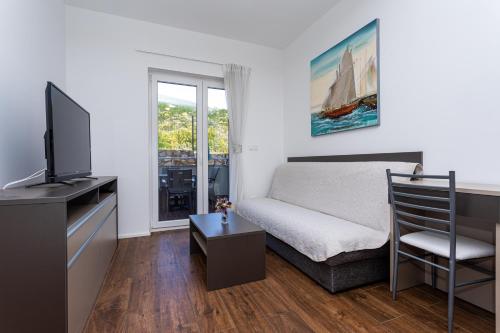 a bedroom with a bed and a tv and a window at Apartments Crnekovic Tomislava 8A in Baška