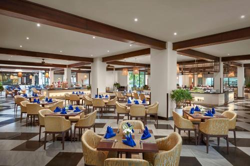 Best Western Premier Sonasea Villas Phu Quoc في فو كووك: مطعم بطاولات وكراسي في مبنى