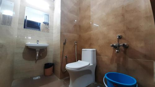 y baño con aseo y lavamanos. en Hotel Stayinn Thanjavur, en Thanjāvūr