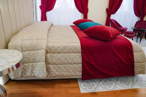 a bedroom with a bed with red and blue pillows at Rosetta Burger Queen in Cagliari