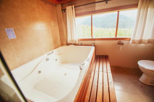 a bathroom with a bath tub and a toilet at Refúgio do Sol Campestre in Urubici