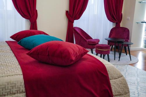 a bedroom with a bed with red pillows and chairs at Rosetta Burger Queen in Cagliari