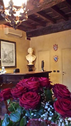 a room with a bunch of roses and a statue at Hotel Torre di San Martino in Gazzola Di Rivalta