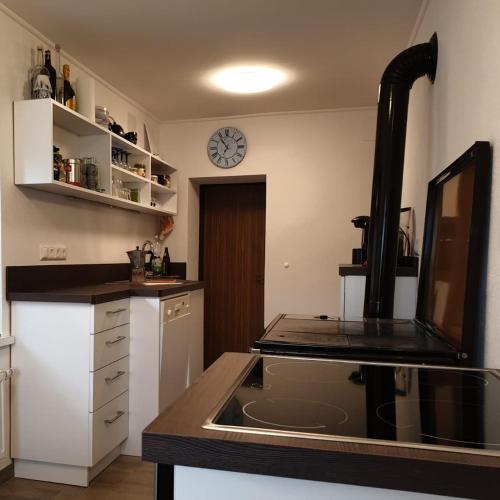 a kitchen with a sink and a clock on the wall at Ferienhaus Annemarie in Ludmannsdorf