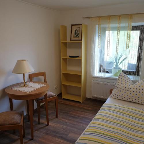 a bedroom with a bed and a table with a lamp at Ferienhaus Annemarie in Ludmannsdorf
