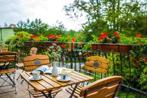 a wooden table and chairs on a balcony with flowers at Park Hotel Kur & Spa in Świeradów-Zdrój