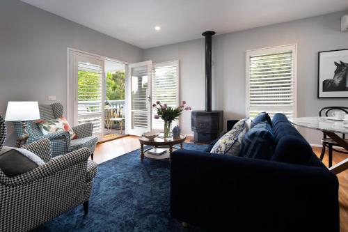 a living room with a couch and chairs at Lake Orchard Villas in Daylesford
