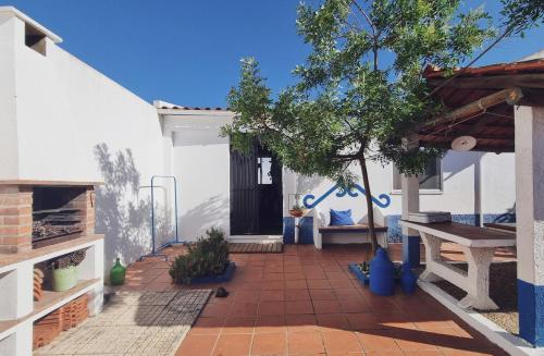 eine Terrasse mit einem Holztisch und einem Baum in der Unterkunft Quintinha do Sal - Casa das Flores in Alcácer do Sal