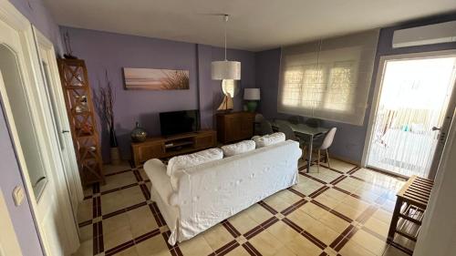 een woonkamer met een witte bank en een tafel bij Piscis Family Bungalow La Manga in La Manga del Mar Menor