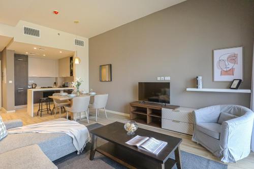 ドバイにあるWelHome - Evergreen Apartment Amidst Vibrant JVC With Poolのリビングルーム(ソファ、テーブル付)