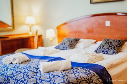 two beds in a hotel room with towels on them at Park Hotel Kur & Spa in Świeradów-Zdrój