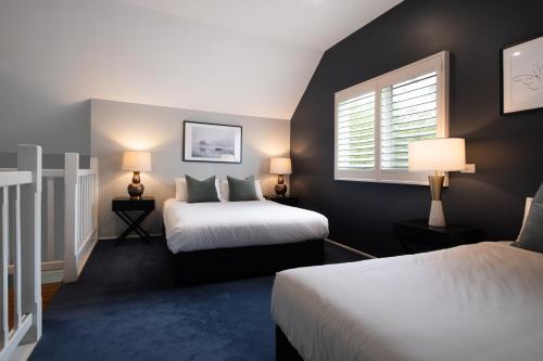 デイルスフォードにあるLake Orchard Villasのベッド2台と窓が備わるホテルルームです。