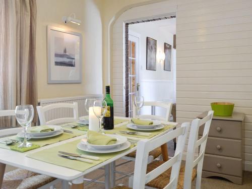 a dining room with a white table and white chairs at South Cross Slacks Farmhouse in Crovie
