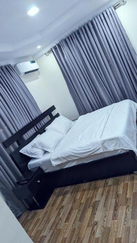un letto a baldacchino in una camera da letto di Naboya House Serviced Apartment a Benin City