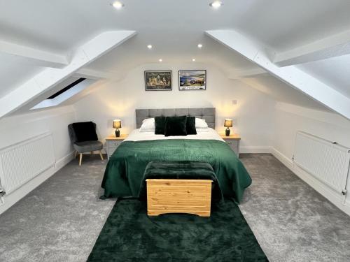 a attic bedroom with a bed and a chair at Luxurious Harrogate Penthouse with Free Parking in Harrogate
