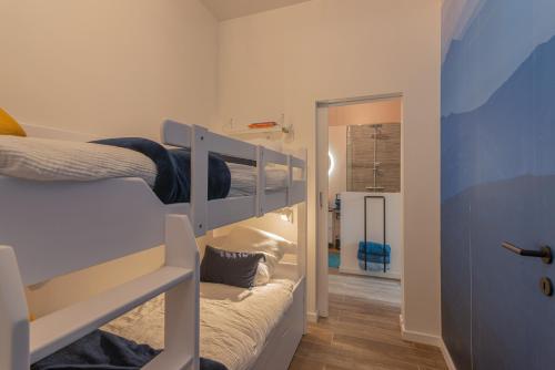 a small room with two bunk beds and a hallway at Superbe appartement 2 chambres dans un clos privé proche de Waterloo in Genappe