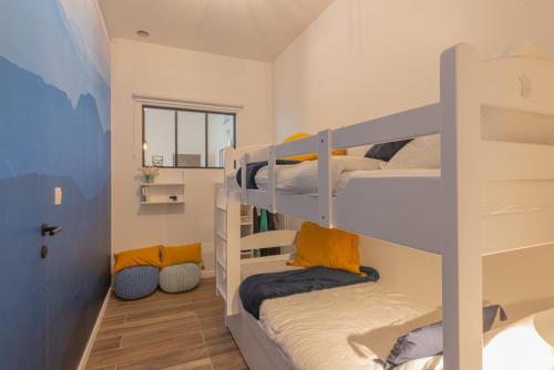 Cette chambre comprend 3 lits superposés et un couloir. dans l'établissement Superbe appartement 2 chambres dans un clos privé proche de Waterloo, à Genappe