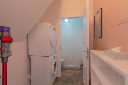 a small bathroom with a washer and dryer in it at Superbe appartement 2 chambres dans un clos privé proche de Waterloo in Genappe