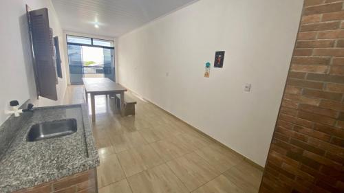 a bathroom with a sink and a table in a room at Apartamento com área Gourmet Arroio do Silva in Arroio do Silva