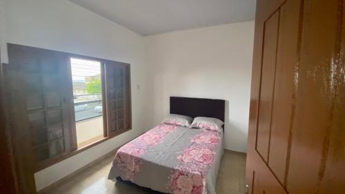 a small bedroom with a bed and a window at Apartamento com área Gourmet Arroio do Silva in Arroio do Silva