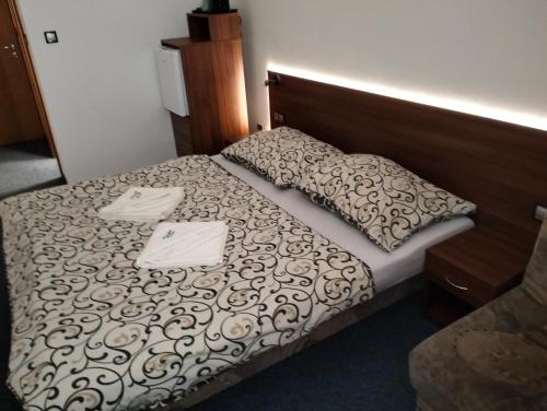 a hotel room with a bed with two towels on it at Penzion Agrothermal in Bešeňová