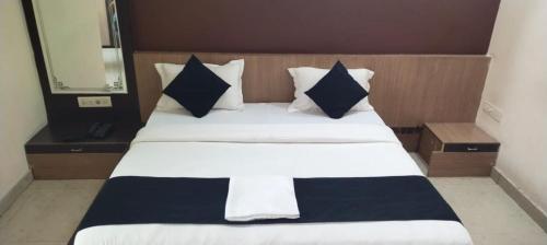 a large bed with black and white sheets and pillows at Hotel K J International in Pura Raghunāth
