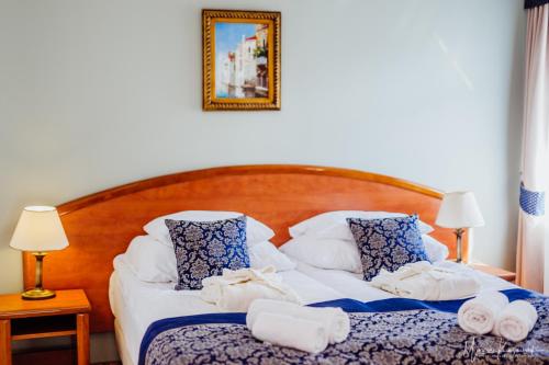a bedroom with a bed with towels on it at Park Hotel Kur & Spa in Świeradów-Zdrój
