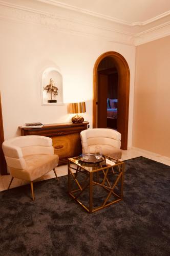 a living room with two chairs and a coffee table at Private Spa Lodge Odenwald in Lindenfels