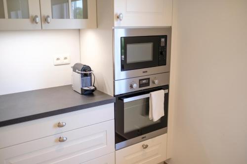 a kitchen with a microwave oven and a microwave at Appartement cocooning 1 chambre proximité Golf Waterloo à Lasnes in Lasne