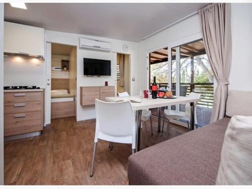 Habitación con cama y cocina con mesa en Mobilne kućice Lavanda, en Osor