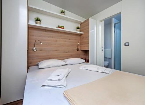 ein weißes Bett mit zwei weißen Kissen darauf in der Unterkunft Mobilne kućice Lavanda in Osor