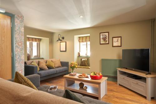 a living room with a couch and a tv at Hope & Anchor in Hope Cove