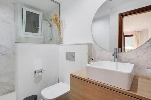 een witte badkamer met een wastafel en een spiegel bij Casa Vista Faro in La Laguna