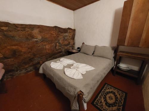 a bedroom with a bed with towels on it at Pouso do Tropeiro - Cavalgadas Roseta in Baependi