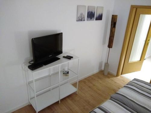 a living room with a tv on a white cabinet at Ferienwohnungen Op der Kees in Irsch