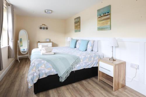 1 dormitorio con 1 cama grande y espejo en GlenHaven Holiday Accommodation, en Glenariff