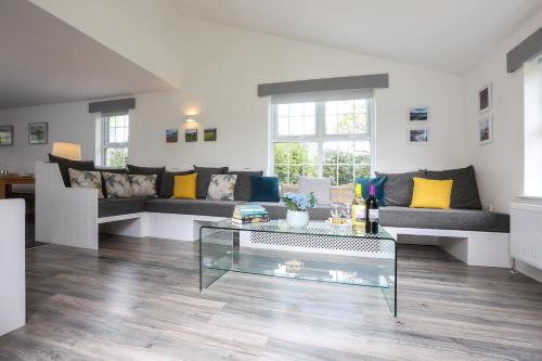 a living room with couches and a glass coffee table at GlenHaven Holiday Accommodation in Glenariff