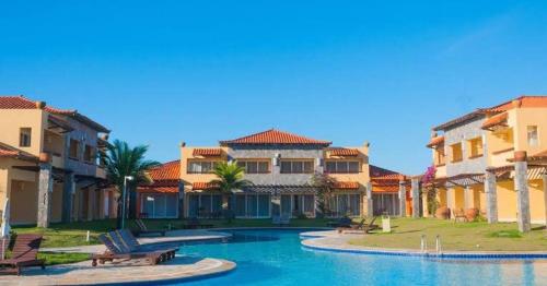 a resort with a swimming pool and some buildings at Hotel Búzios Resort com Entretenimento in Búzios