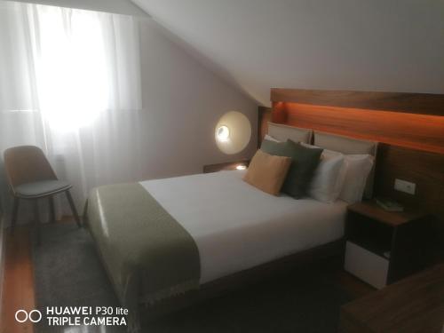 a bedroom with a bed and a window and a chair at Timeless - Energy - Belém in Lisbon