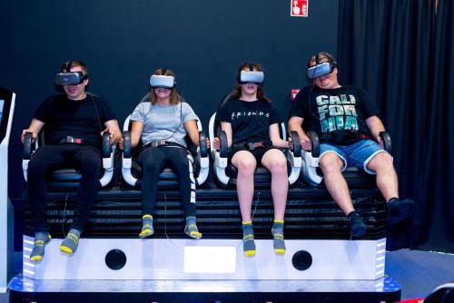 a group of people sitting on a bench wearing virtual reality headsets at Kolping Family Resort in Hévíz